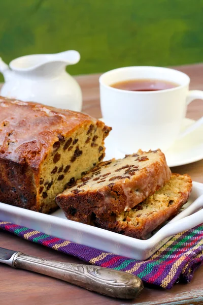 Φέτες κέικ της σταφίδας καρβέλι και φλιτζάνι τσάι — Φωτογραφία Αρχείου