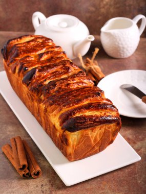 Tarçın şekeri ekmeği ayırıp servis eder.