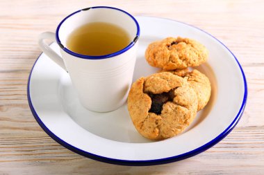 Meyve kıymalı sürpriz kurabiyeler ve bir fincan yeşil çay.