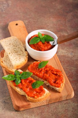 Ekmek dilimlerinin üzerine yayılmış kızarmış sebzeler.