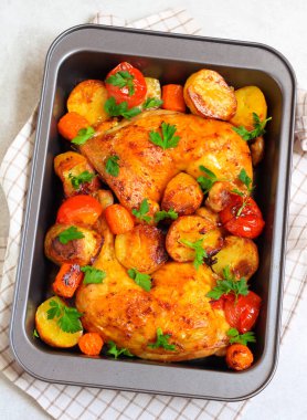 Kızarmış tavuk bacağı, patates, havuç ve domates.