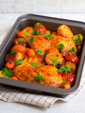 Kızarmış tavuk bacağı, patates, havuç ve domates.