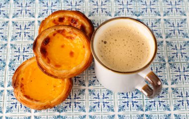 Pastel de nata geleneksel Portekiz usulü kremalı tart ve bir fincan kahve.