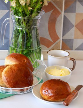 Tam tahıllı kahvaltı, rulo ekmek, tereyağı ve kahve ile servis edilir.