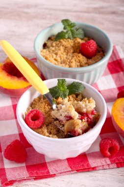 Peach and raspberry crumble cake in ceramic ramekins