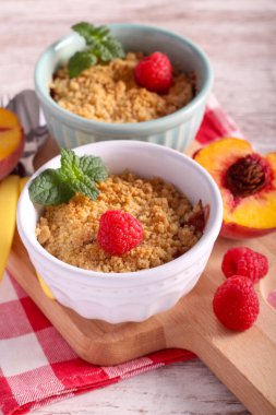 Peach and raspberry crumble cake in ceramic ramekins