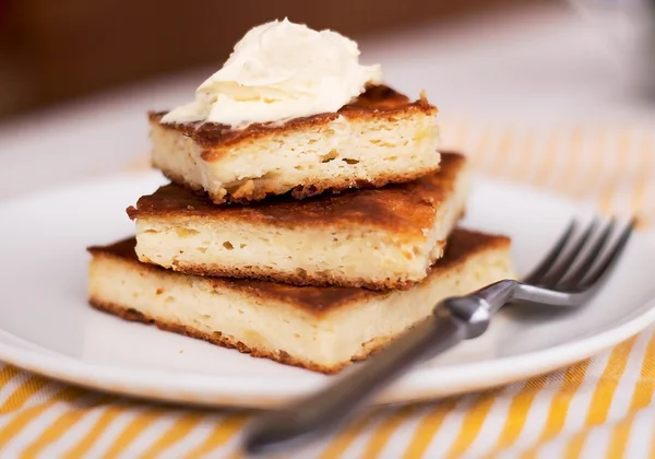 Stücke Käsekuchen und Sahne, Honig — Stockfoto