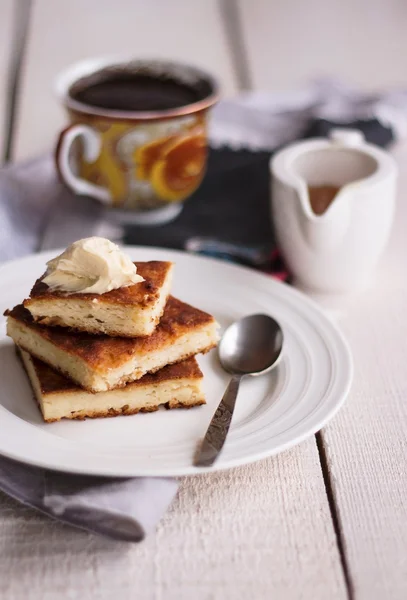 Bitar cheesecake och en grädde, honung, kaffe — Stockfoto