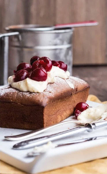 Chocolate cake with cream cheese, raw cherry on white plate — Stock Photo, Image