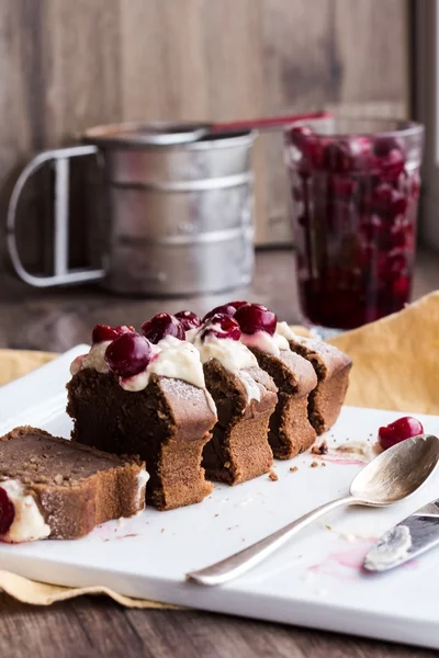 Kusy čokoládový dort se smetanovým krémem, syrové cherry na bílém pla — Stock fotografie