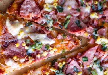 parça pizza sucuk, tavuk, Mısır ve peynir kesti