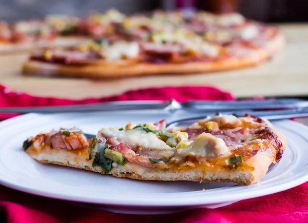 Fette di pizza su un piatto, un tavolo bianco e una posata — Foto Stock