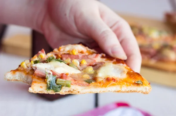 Äta en bit pizza händer — Stockfoto