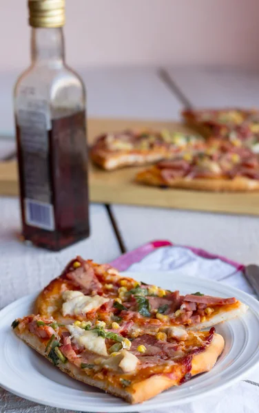 Pizza auf einem Teller, weißer Tisch und Besteck — Stockfoto