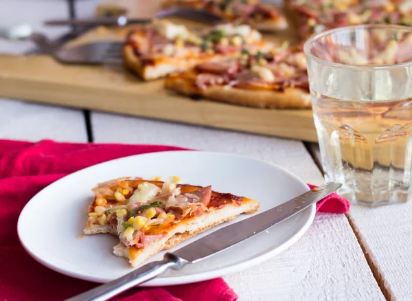 Pizzascheiben auf einem Teller, Tisch und einem Glas Limo — Stockfoto