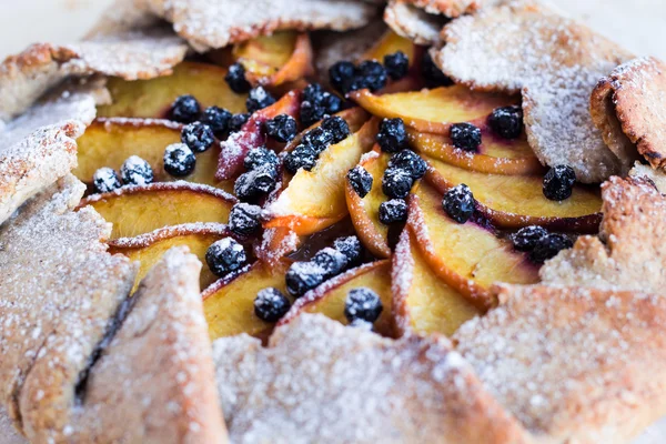 Gebackene Kekse mit Pfirsich und Blaubeere auf weißem Tisch — Stockfoto