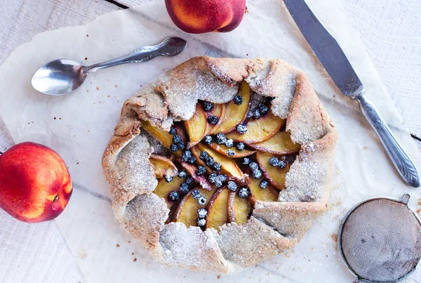 Baked biscuits with peach and blueberry on a white table — Stock Photo, Image