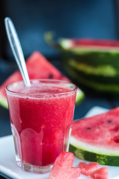 Pastèque dans un verre de smoothieon sur la planche, fond blanc — Photo