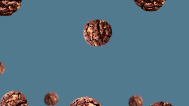 不同直径的美味巧克力片饼干在4K超高清镜头的蓝色背景 水平的 不易碎的 上移动到中心 — 图库视频影像