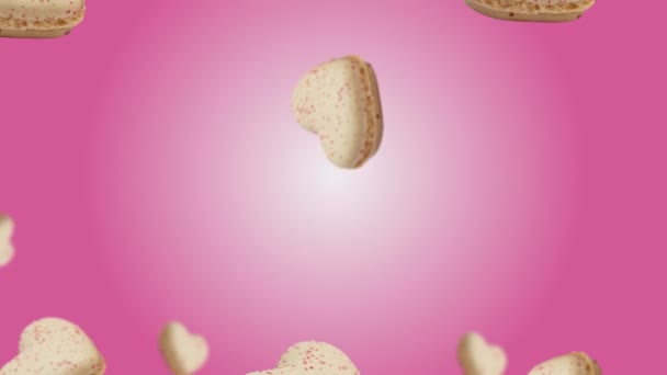 香草马卡龙心形饼干飞舞在流行的粉色彩色动画背景上 糕点店概念 爱母亲节的模板 4K甜点镜头 — 图库视频影像
