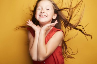 Küçük kız vücudunda neşe ve duygusunu ifade ederken, yüzünde modaya uygun şirin bir etki bırakıyor..