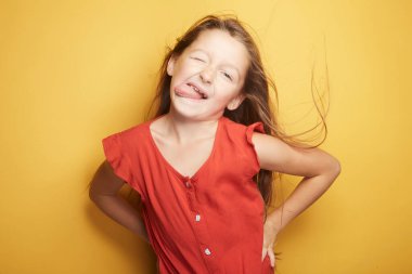 Küçük kız vücudunda neşe ve duygusunu ifade ederken, yüzünde modaya uygun şirin bir etki bırakıyor..