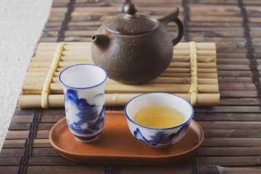 Bambu hasırlı bir masada çay seti. Porselen bardak.
