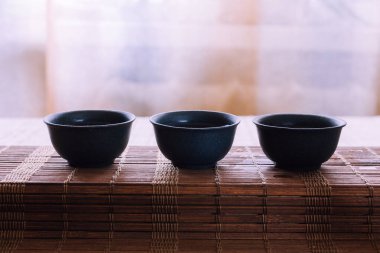 Bambu hasırlı bir masada çay seti. Porselen kaplar