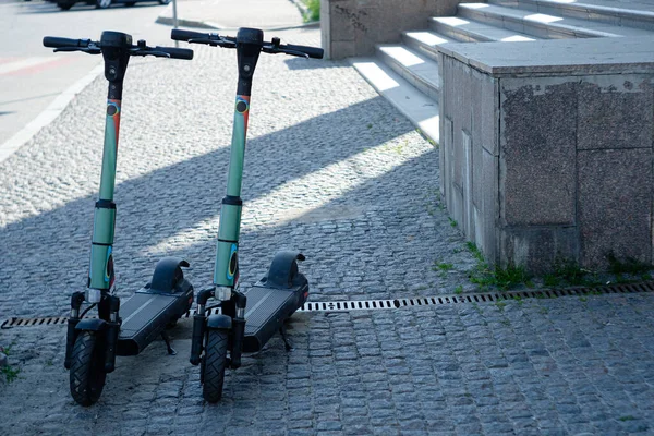 Parking E-scooters, Eco friendly mobility concept of sharing transportation with Electric Scooter. Summer sunny day, shadows on the street