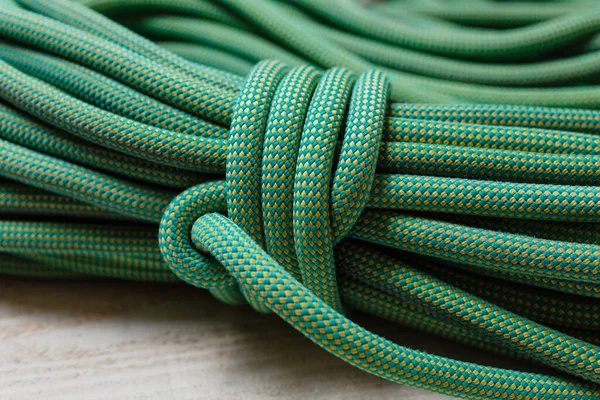 Bayed rope for climbing. Green rope for mountaineering close up. Node