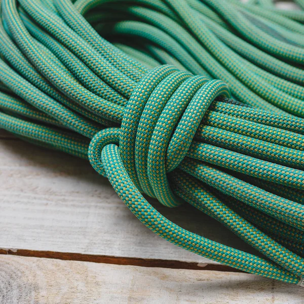 Bayed rope for climbing. Green rope for mountaineering close up. Node