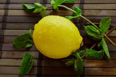 Limon, yaprak ve nane parçalarını yakın plan bambu masasında.