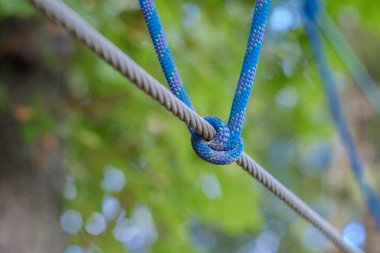 Fastening knot on a cable. The bridges, ropes and ladders of the Adventure Park are designed for beginners among the tall trees.