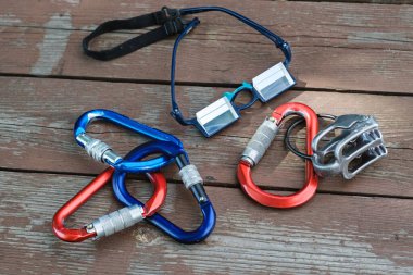 Tahta arka planda asılı kalmak için tırmanma ekipmanları ve prizma gözlükleri.