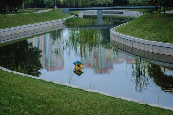 floating house for birds in the city lake of Kyiv. The house is painted in the national colors of Ukraine