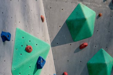 climbing stand simulator outdoors. Artificial holds for training rock climbers. Summer evening light