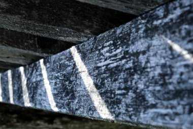 Minimalist tarzda bir geçmiş. Kuru tahtalardan yapılmış eski bir çit ve güneş ışınları delip geçiyor. Karelerden soyutlama.