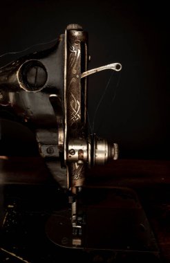 Siyah arka planda eski bir dikiş makinesinin parçası. Retro çekim. Eski tarz konsept.
