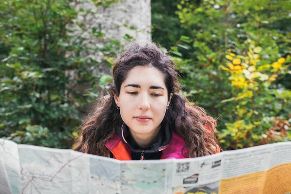 A woman consulting a mountain map. Adventure concept.