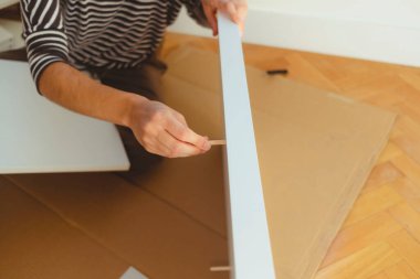 Bir kadının ellerinin bir mobilya parçasını monte ederken yakın plan fotoğrafı..