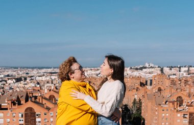 60 yaşında bir anne ve 28 yaşındaki kızının gülümseyerek birbirlerine baktıkları portre. Aile kavramı. Kadın konsepti.