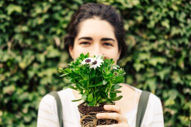 Close-up of a young woman holding some daisies. Nature concept.