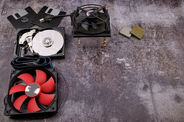 Çimento, sabit diskler, disk sürücüler, grafik denetleyiciler, mikro çipler, pervaneler ve ısı lavaboları gibi farklı bilgisayar bileşenleri gibi koyu bir zemindeki çeşitli bilgisayar bileşenlerinin bileşimi.