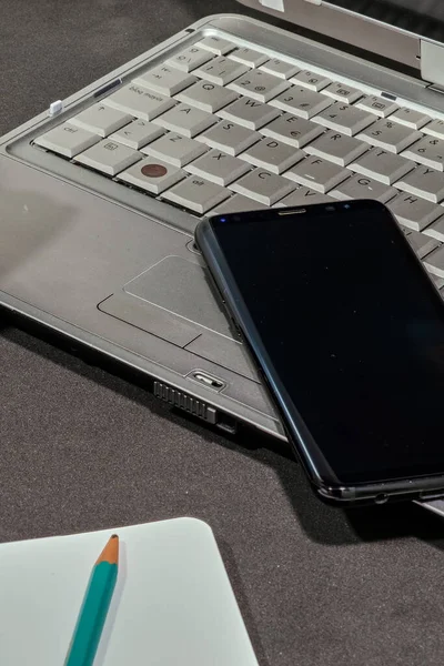 Bir dizüstü bilgisayar, eski bir kamera ve bir not defteri bileşimi