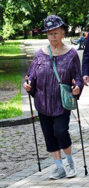 Kiev, Ukrayna 13 Haziran 2021: Modaya uygun şapkalı büyükanne spor için içeri giriyor