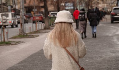 Kiev, Ukrayna 02 Ocak 2022: Genç sarışın bir kız Kiev caddesi boyunca yürüyor