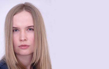 Makyajsız mavi gözlü sarışın bir kızın portresi.