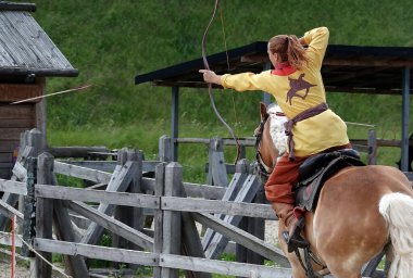 Kiev, Ukraine June 19, 2021: Horse rider shoots a bow at a target in an old outfit - show in the entertainment complex Kievskaya Rus