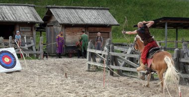 Kiev, Ukraine June 19, 2021: Horse rider shoots a bow at a target in an old outfit - show in the entertainment complex Kievskaya Rus