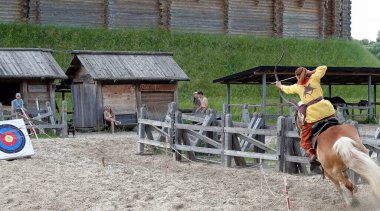 Kiev, Ukraine June 19, 2021: Horse rider shoots a bow at a target in an old outfit - show in the entertainment complex Kievskaya Rus